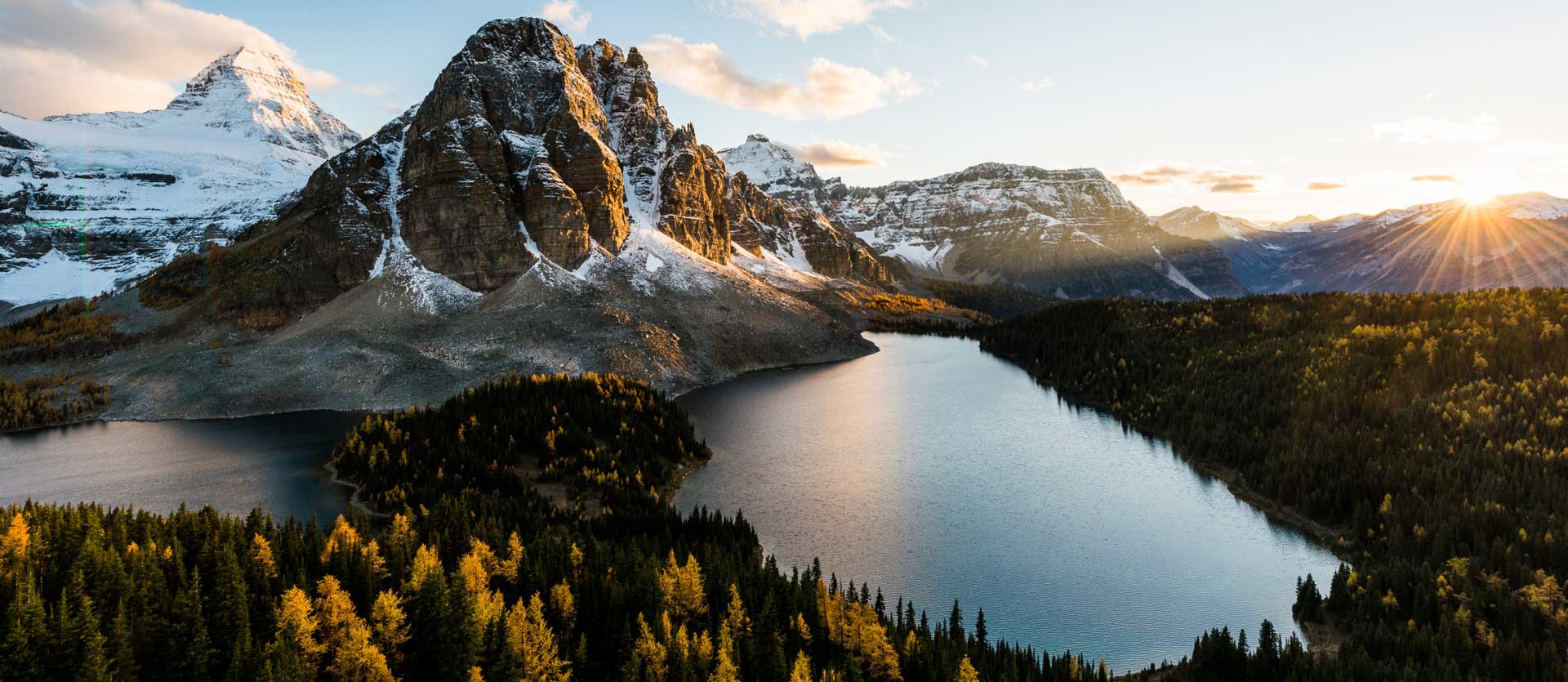 Two lakes in front of steep mountains at sunset